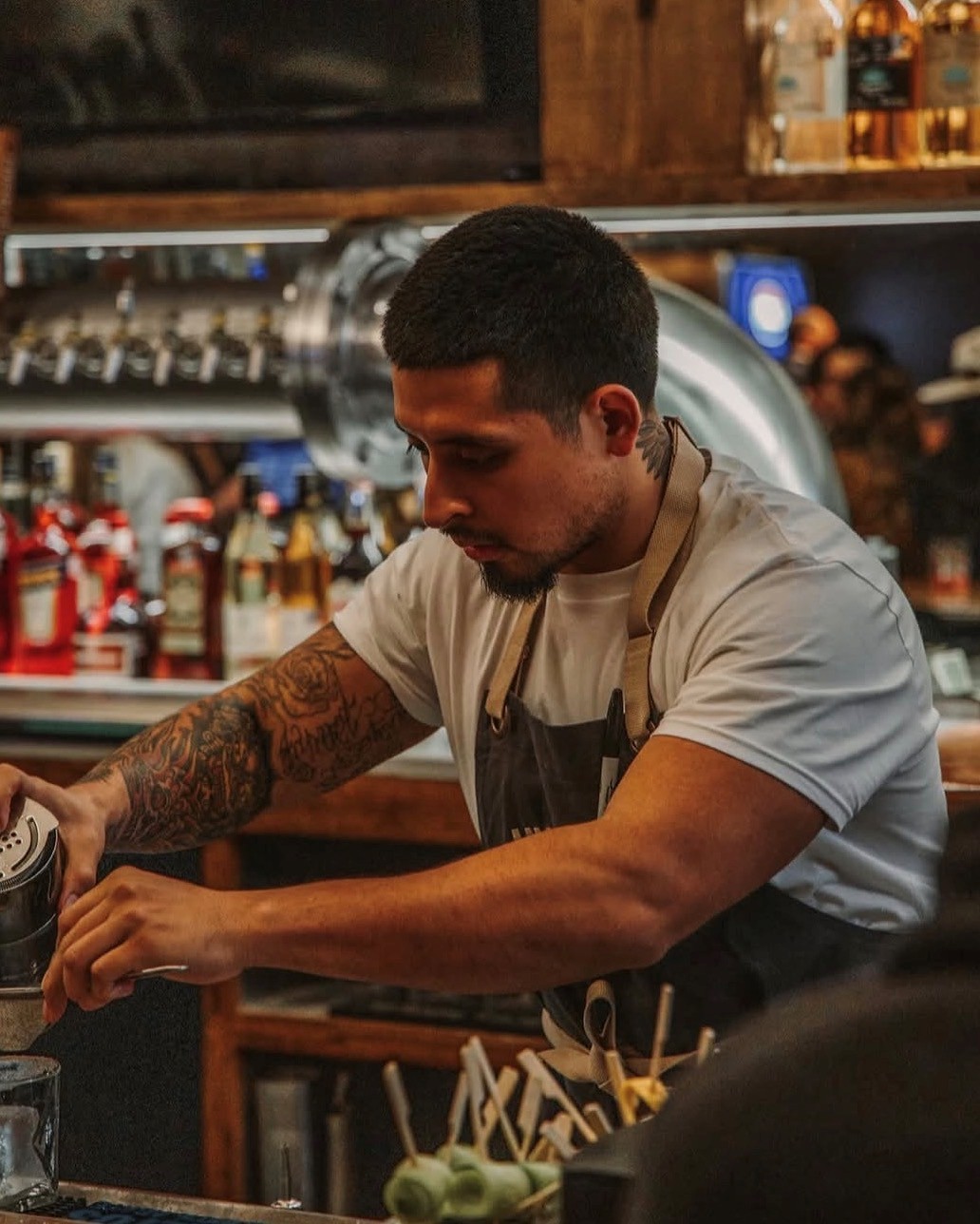 The counter at Hurtado Barbecue, lit low behind the smoke